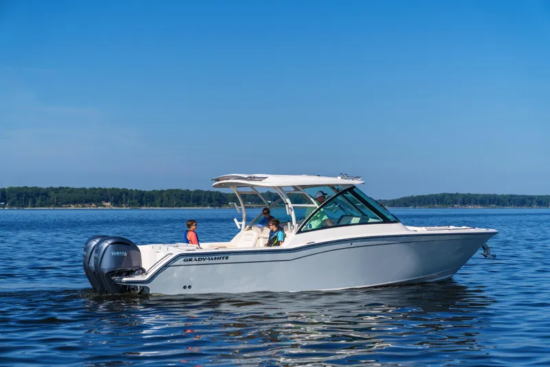 Slide: The Image of 2025 Grady-White Freedom 325 boat cruising on a calm lake under a clear blue sky. - 4