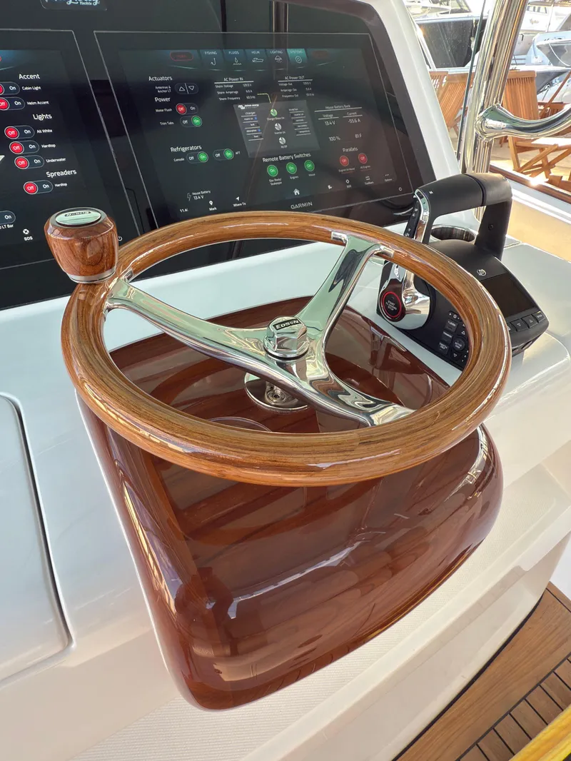 Slide: The Image of 2025 Mag Bay 38 Center Console helm with wooden steering wheel and digital display. - 39