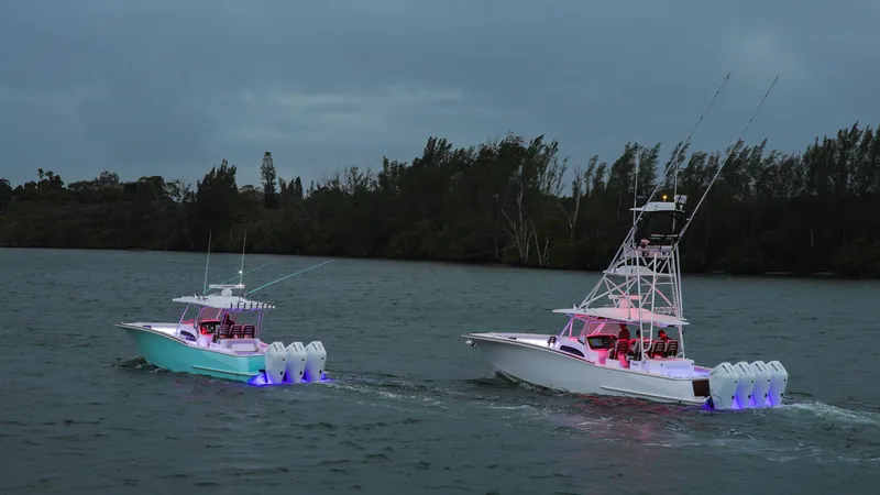 Slide: The Image of 2025 Mag Bay 38 Center Console boats cruising on a lake at dusk. - 17