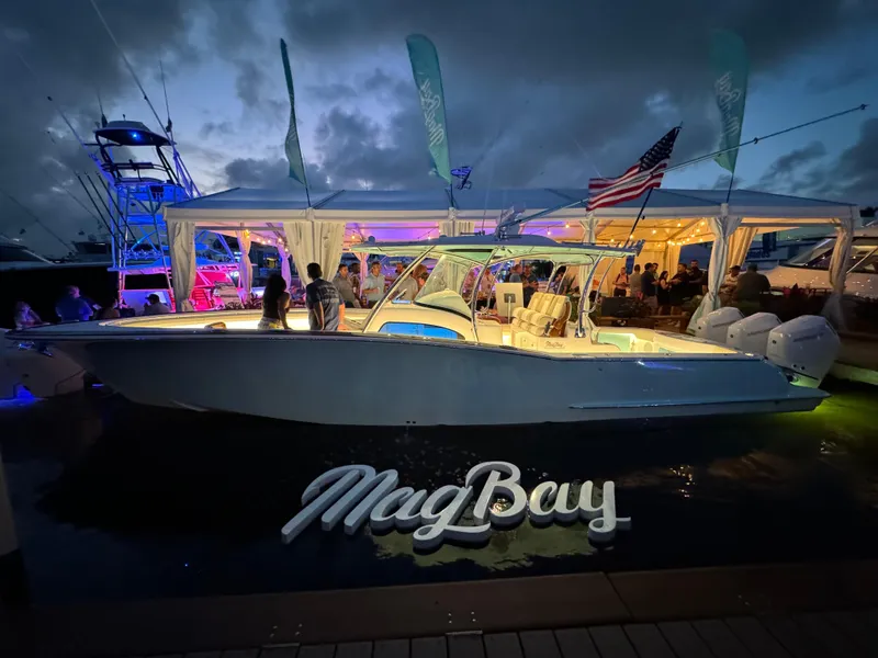 Slide: The Image of 2025 Mag Bay 38 Center Console boat at night, illuminated with vibrant lights. - 23