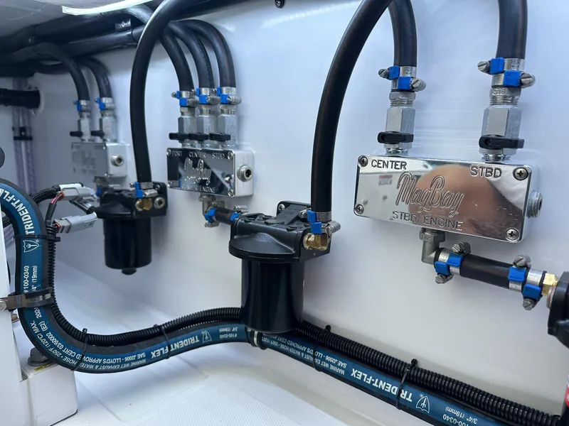 Slide: The Image of 2025 Mag Bay 38 Center Console engine compartment with hydraulic and fuel lines. - 43