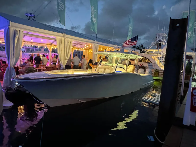 Slide: The Image of 2025 Mag Bay 38 Center Console boat at a vibrant evening event. - 24