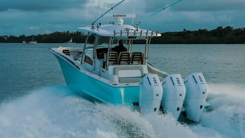 Slide: The Image of 2025 Mag Bay 38 Center Console boat cruising on water with triple engines. - 13