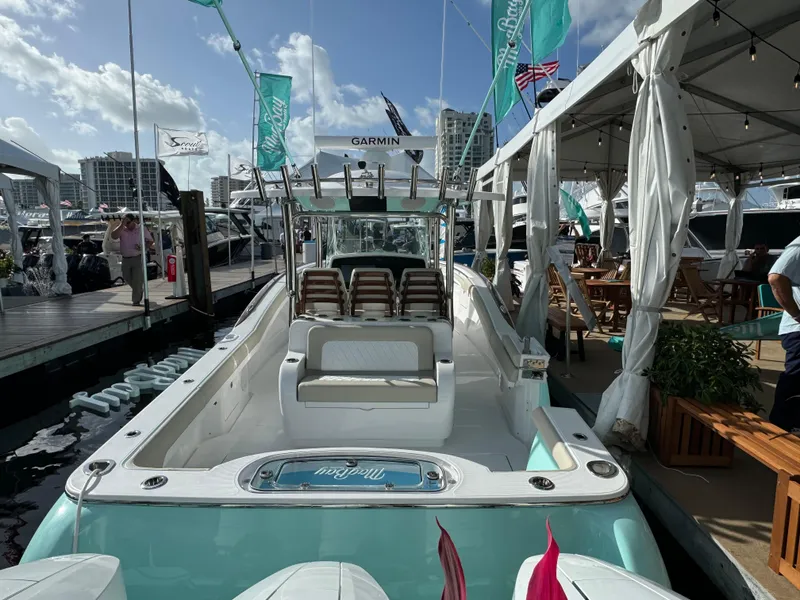 Slide: The Image of 2025 Mag Bay 38 Center Console boat docked at marina, showcasing sleek design and spacious deck. - 19
