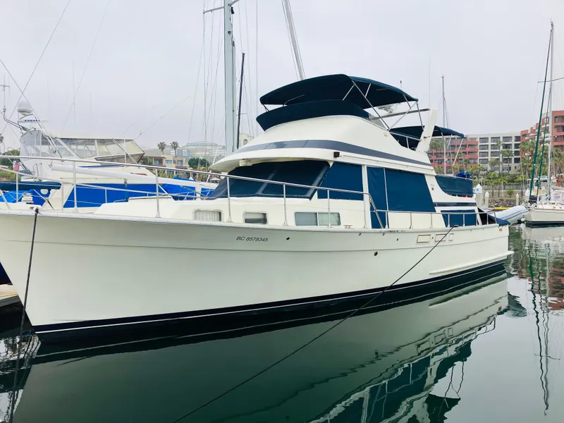 The Image of 1984 Tollycraft 48 Cockpit Motor Yacht docked in marina, featuring blue and white design. - 1