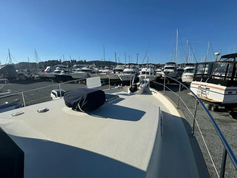 Slide: The Image of 1984 Tollycraft 48 Cockpit Motor Yacht docked among other boats under clear blue sky. - 12