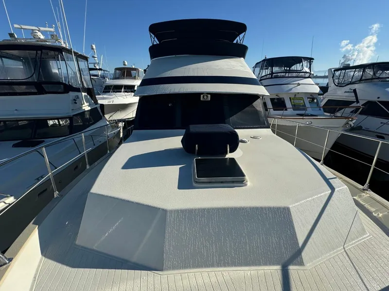 Slide: The Image of 1984 Tollycraft 48 Cockpit Motor Yacht docked among other boats under clear blue sky. - 15