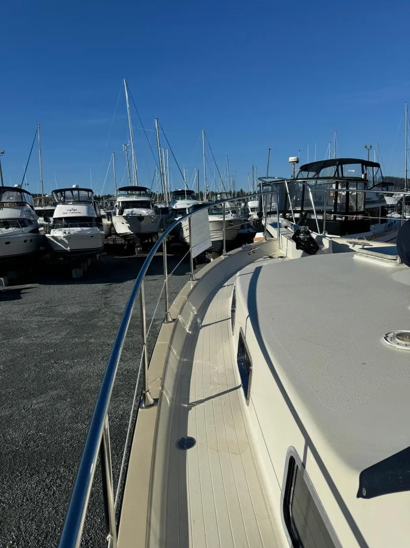 Slide: The Image of 1984 Tollycraft 48 Cockpit Motor Yacht docked among other boats under a clear blue sky. - 17