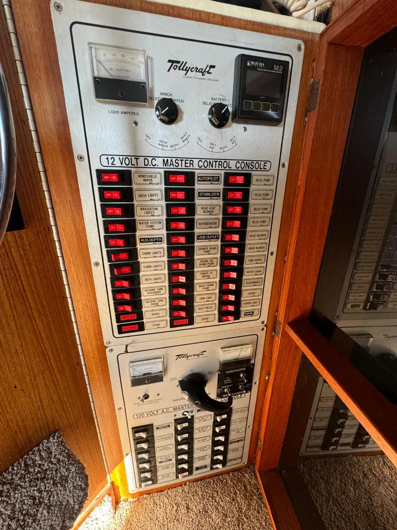 Slide: The Image of 1984 Tollycraft 48 Cockpit Motor Yacht control panel with switches and gauges. - 19