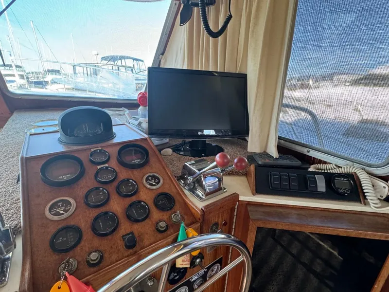Slide: The Image of 1984 Tollycraft 48 Cockpit Motor Yacht helm with gauges, steering wheel, and monitor. - 28