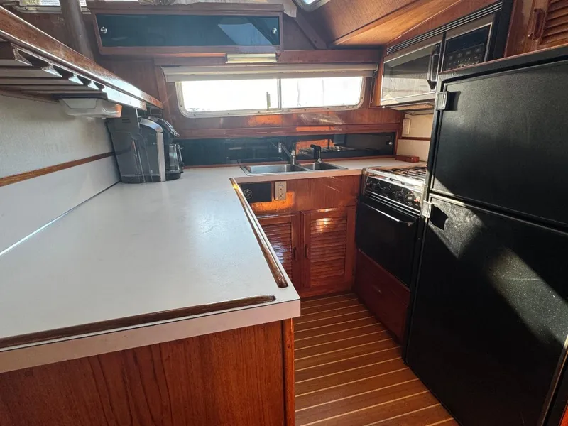 Slide: The Image of 1984 Tollycraft 48 Cockpit Motor Yacht kitchen with wood cabinetry and modern appliances. - 38