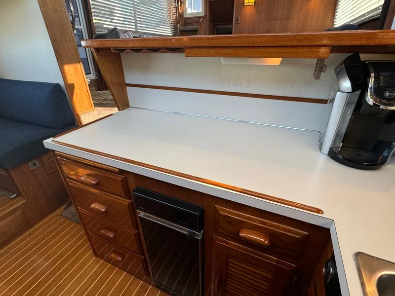Slide: The Image of 1984 Tollycraft 48 Cockpit Motor Yacht kitchen with wooden cabinets and countertop. - 42