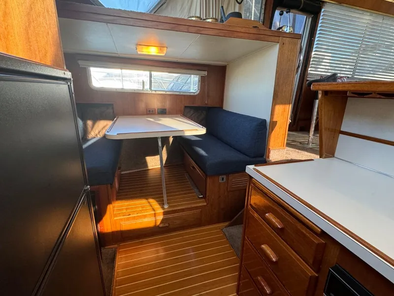 Slide: The Image of 1984 Tollycraft 48 Cockpit Motor Yacht interior with dining area and wooden cabinetry. - 43