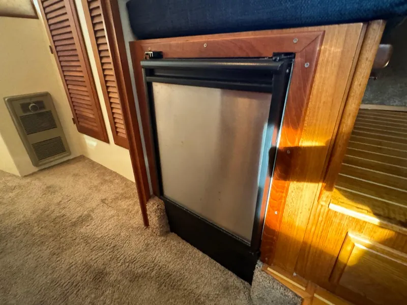 Slide: The Image of Compact refrigerator in 1984 Tollycraft 48 Cockpit Motor Yacht interior, surrounded by wood paneling. - 45