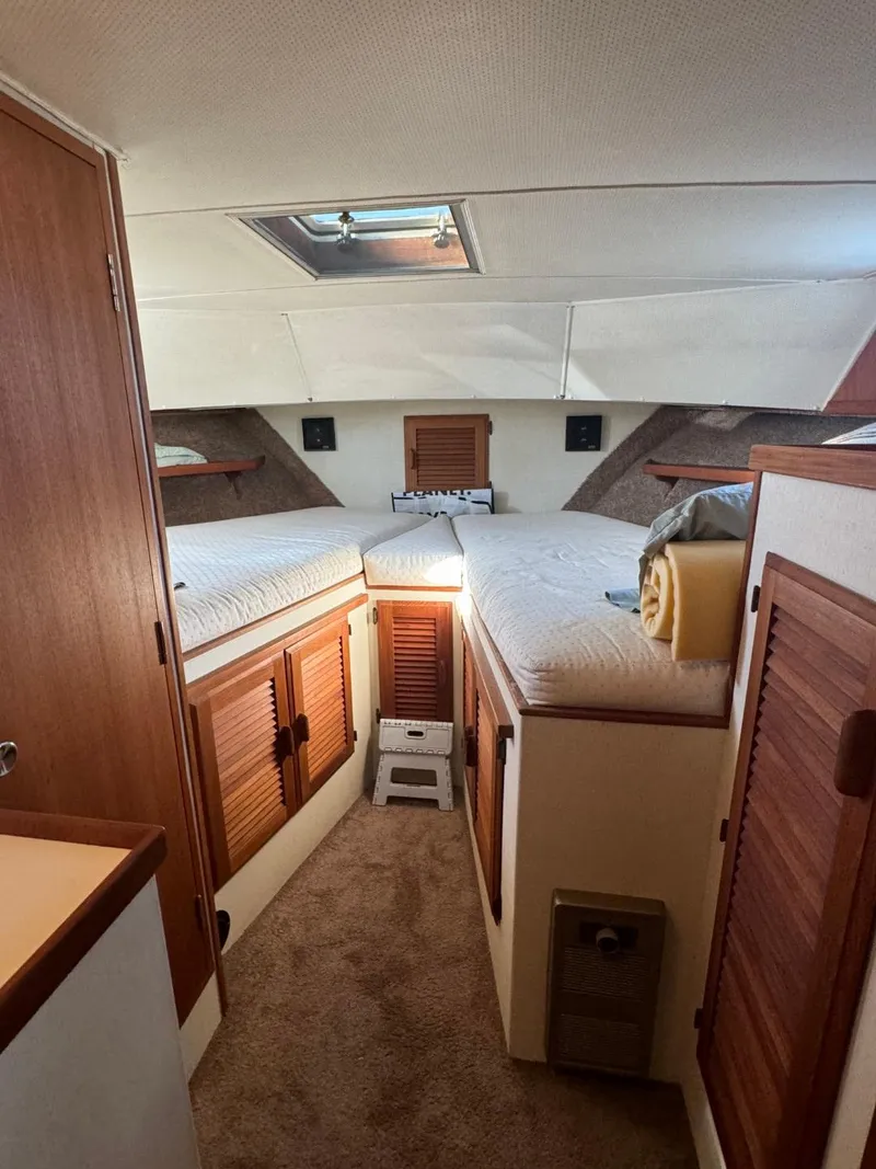 Slide: The Image of 1984 Tollycraft 48 Cockpit Motor Yacht interior with twin beds and wooden cabinetry. - 46