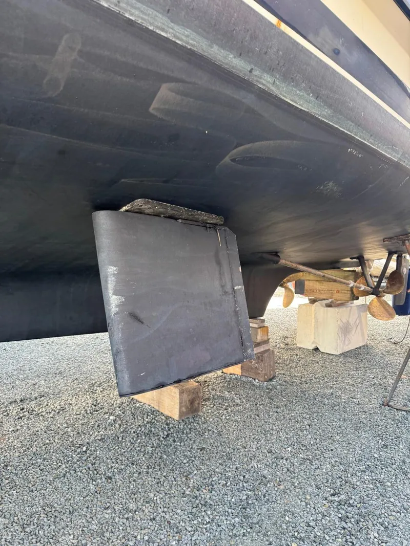 Slide: The Image of 1984 Tollycraft 48 Cockpit Motor Yacht hull on blocks, showcasing rudder and propeller. - 6