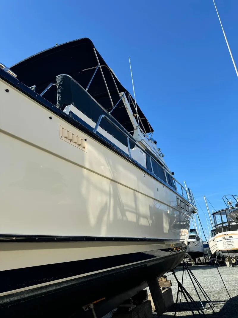Slide: The Image of 1984 Tollycraft 48 Cockpit Motor Yacht on dry dock under clear blue sky. - 8