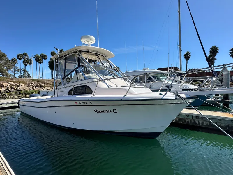 The Image of 2002 Grady-White 282 Sailfish boat docked in marina under clear blue sky. - 1