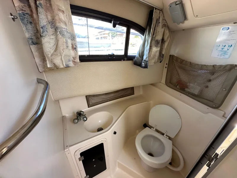 Slide: The Image of 2002 Grady-White 282 Sailfish boat bathroom with sink, toilet, and window. - 12