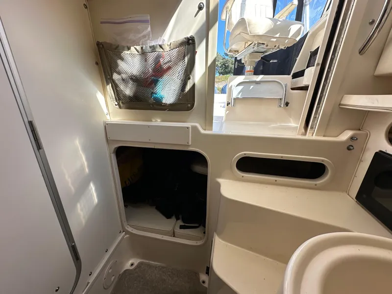 Slide: The Image of Interior of 2002 Grady-White 282 Sailfish boat, featuring storage compartments and seating area. - 16