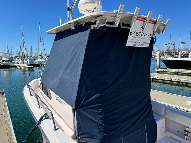 Slide: The Image of 2002 Grady-White 282 Sailfish boat docked at marina with blue cover. - 17