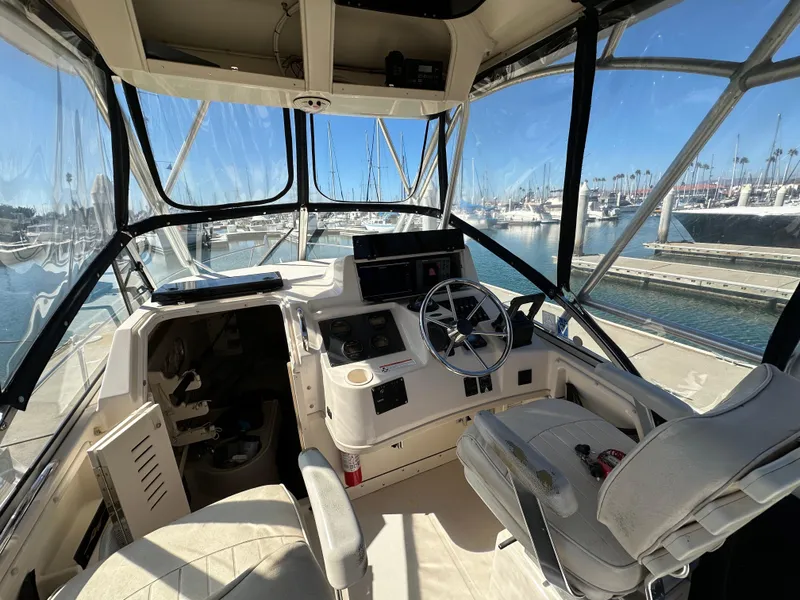 Slide: The Image of 2002 Grady-White 282 Sailfish boat cockpit with steering wheel and marina view. - 8