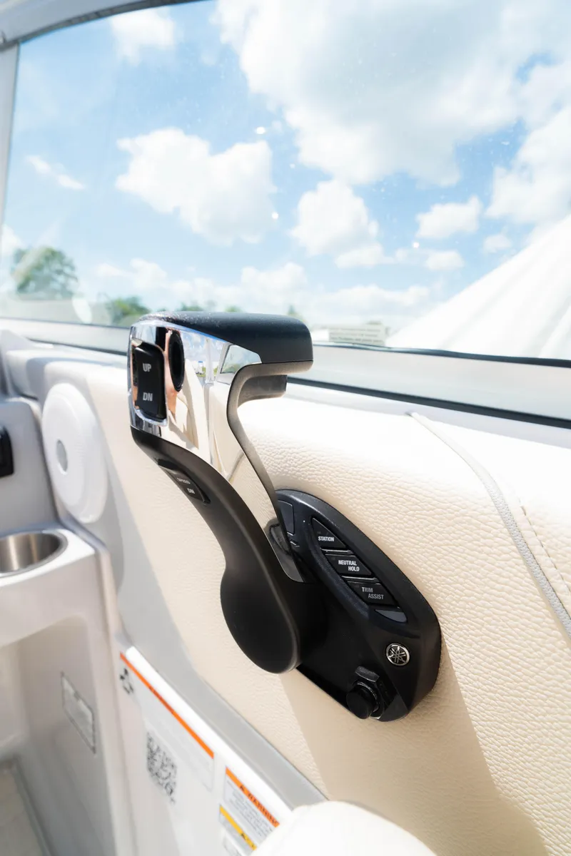 Slide: The Image of 2023 Regal 26 XO boat throttle control against a clear blue sky. - 13