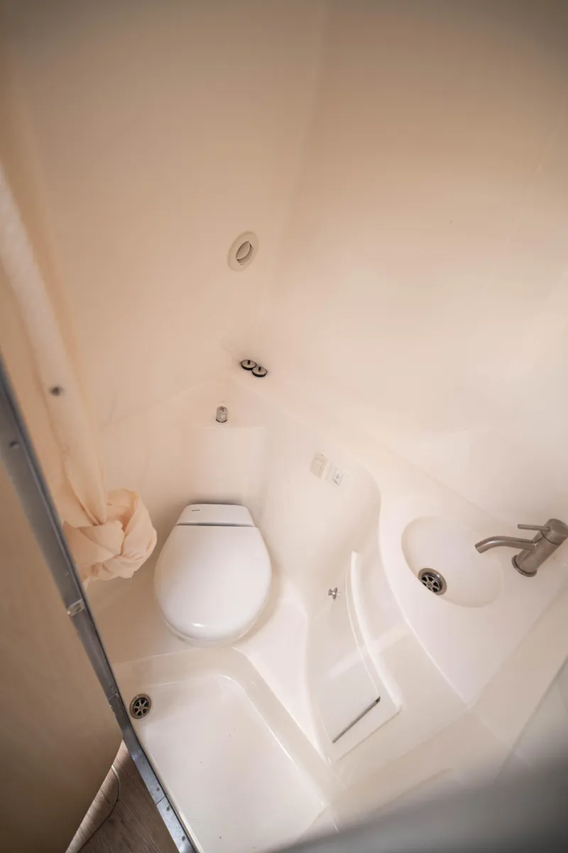 Slide: The Image of 2023 Regal 26 XO boat bathroom with toilet and sink, compact and modern design. - 6