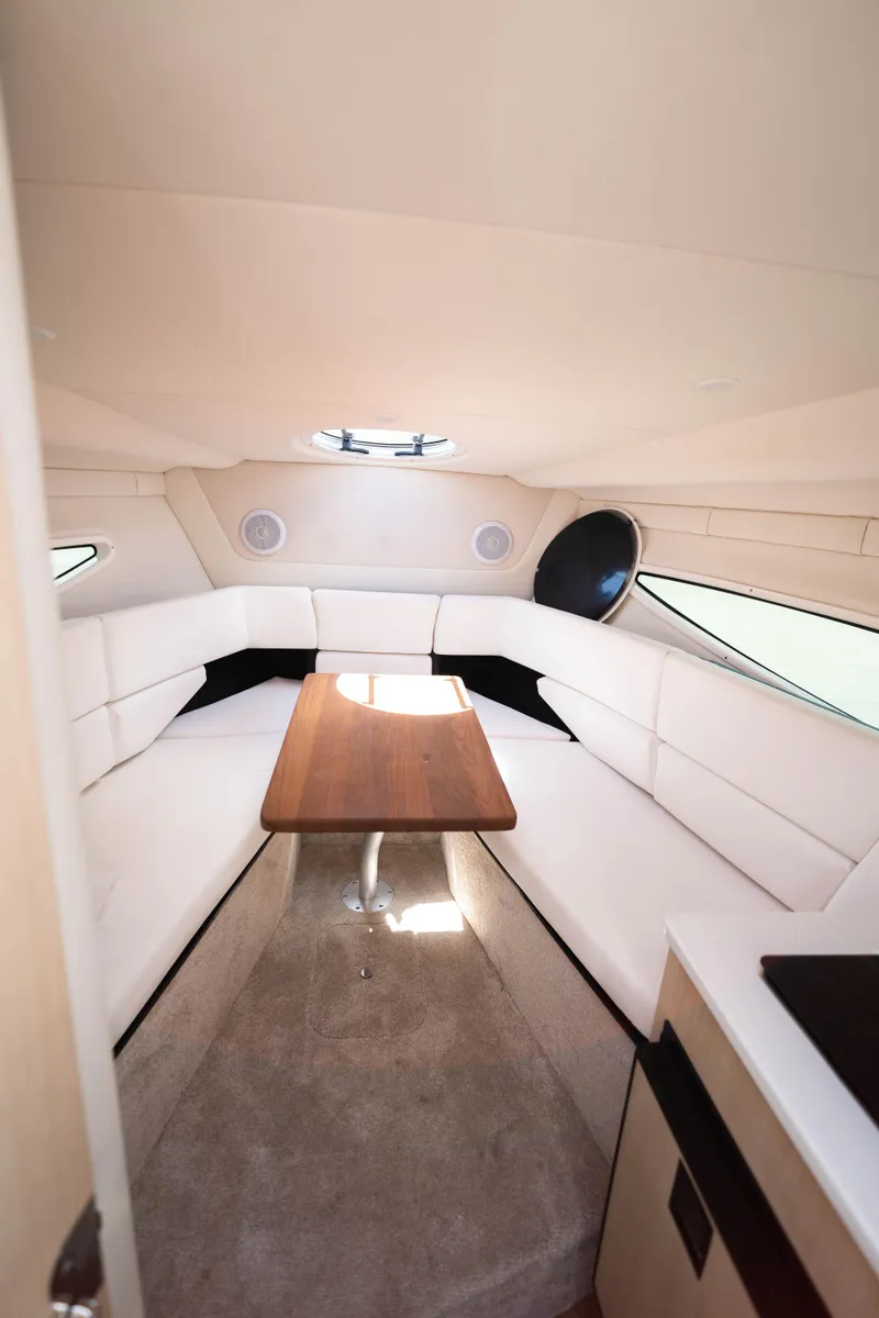 Slide: The Image of 2023 Regal 26 XO cabin interior with white seating and wooden table. - 7