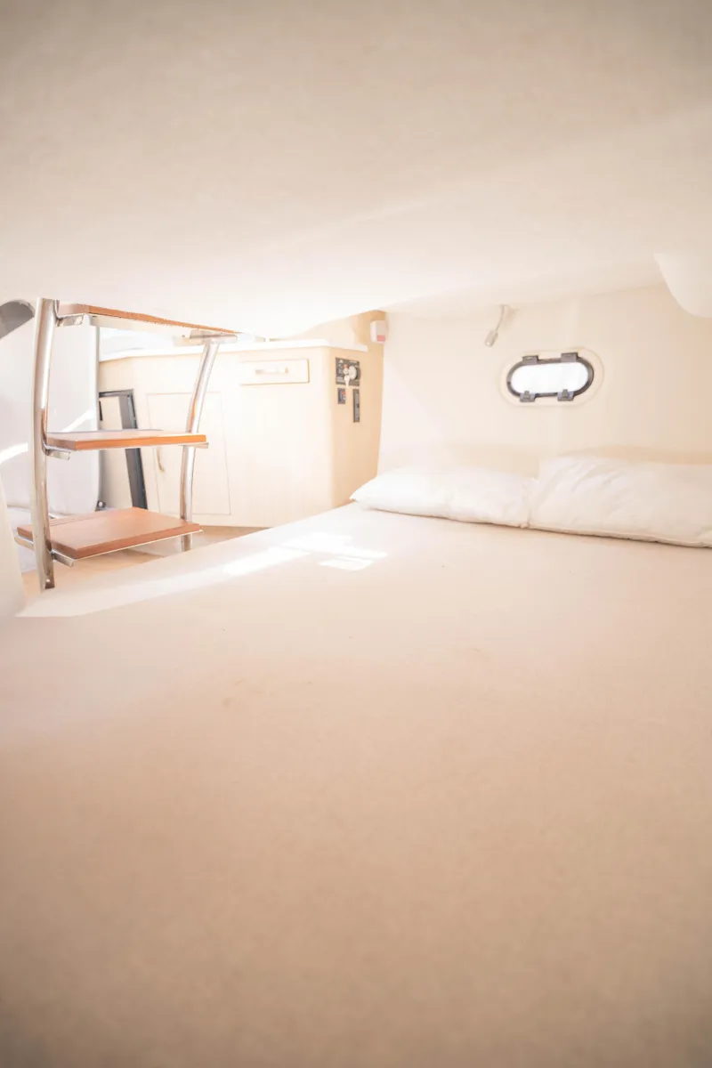 Slide: The Image of 2023 Regal 26 XO cabin interior with bed and porthole window. - 8