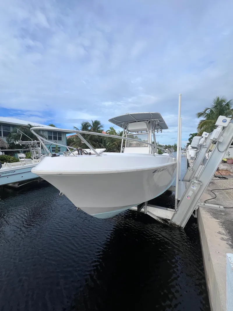 The Image of 1997 Mako 252 Center Console boat docked by waterfront homes. - 1