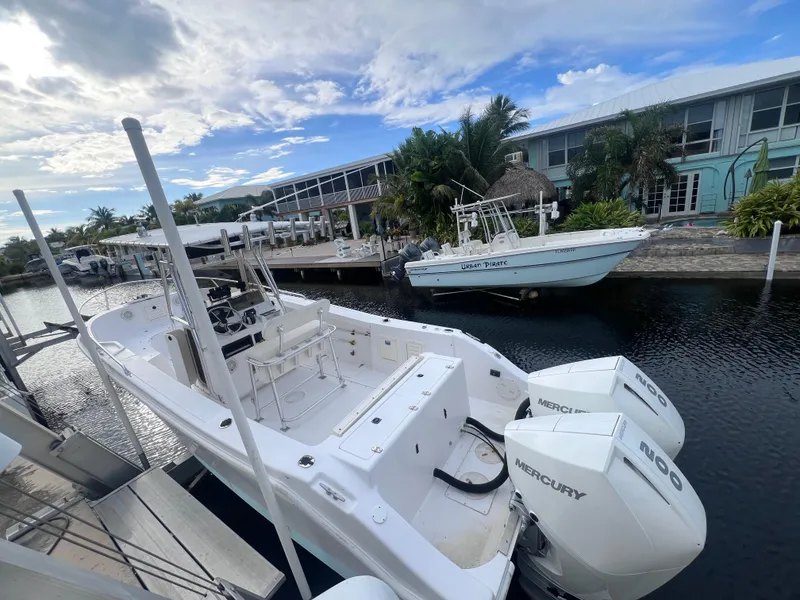 Slide: The Image of 1997 Mako 252 Center Console boat docked by waterfront homes. - 3