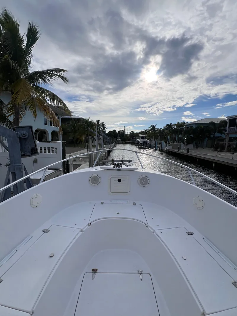 Slide: The Image of 1997 Mako 252 Center Console boat on a scenic canal with cloudy sky. - 4