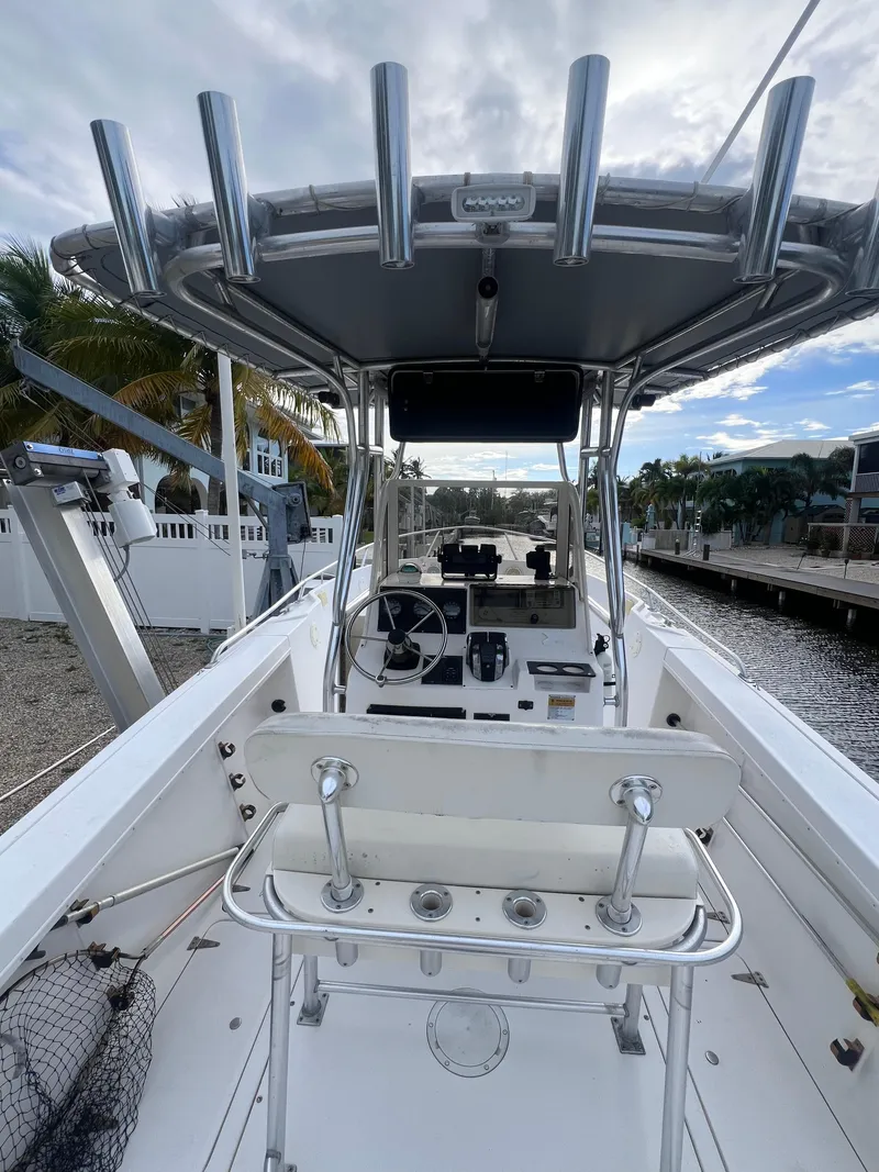 Slide: The Image of 1997 Mako 252 Center Console boat docked, featuring a spacious helm and rod holders. - 6