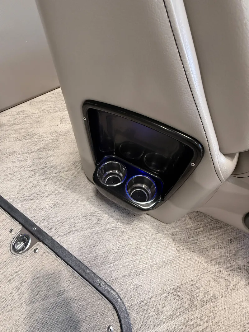 Slide: The Image of 2019 Manitou 25 SES Platinum boat interior with dual cup holders. - 12