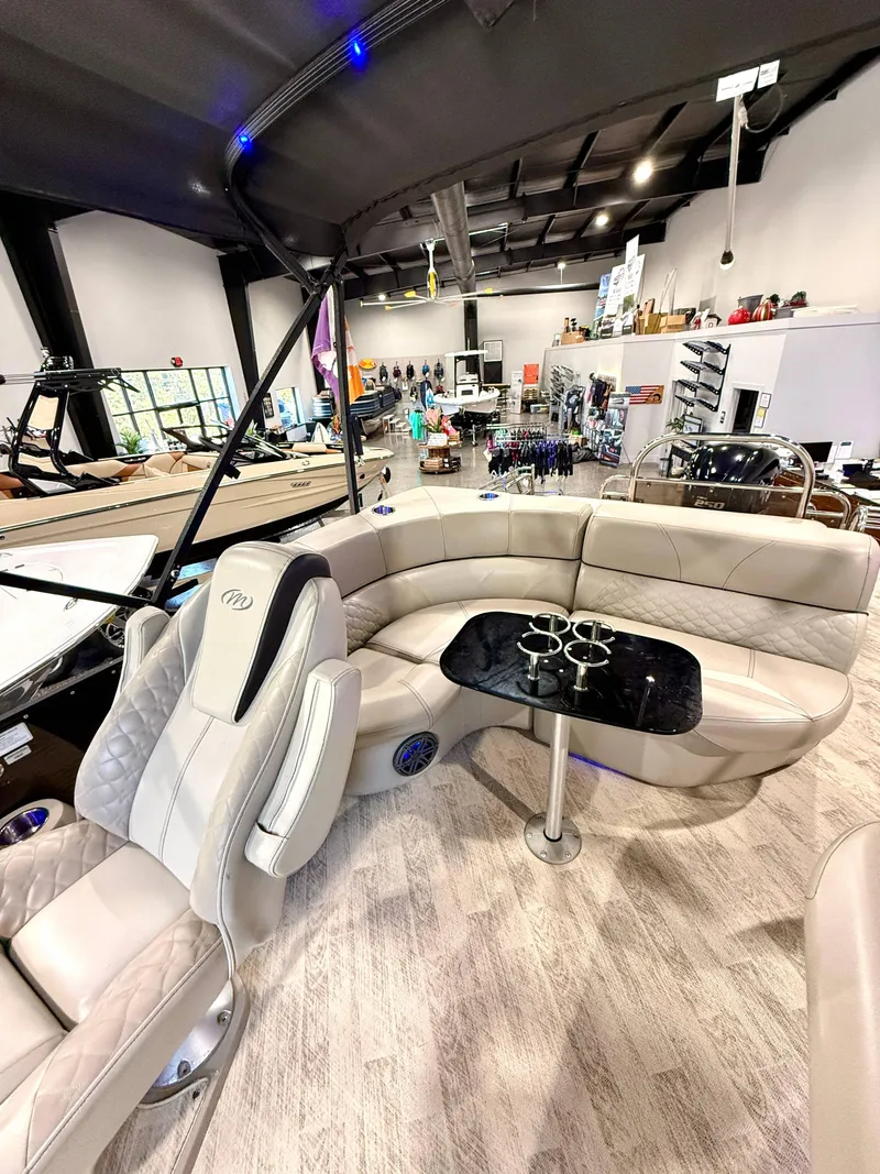 Slide: The Image of 2019 Manitou 25 SES Platinum pontoon boat interior with luxurious seating and table. - 13