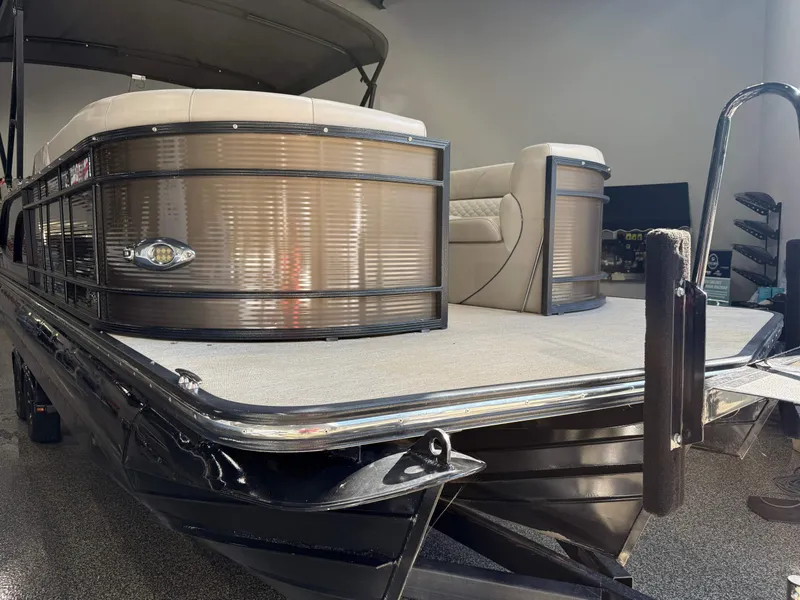 Slide: The Image of 2019 Manitou 25 SES Platinum pontoon boat in showroom, featuring sleek design and comfortable seating. - 21
