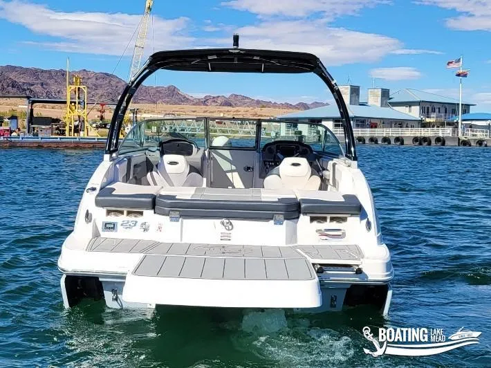 Slide: The Image of 2021 Chaparral 23 Surf boat on water, rear view, sunny day, marina background. - 15