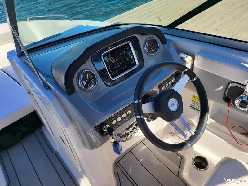 Slide: The Image of 2021 Chaparral 23 Surf boat dashboard with steering wheel and controls. - 7