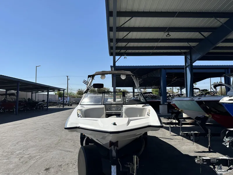 Slide: The Image of 2012 Axis A22 boat parked under a metal canopy in a marina. - 1