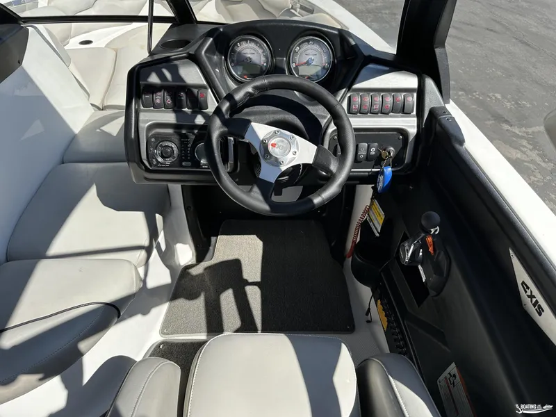 Slide: The Image of 2012 Axis A22 boat cockpit with steering wheel and dashboard controls. - 10