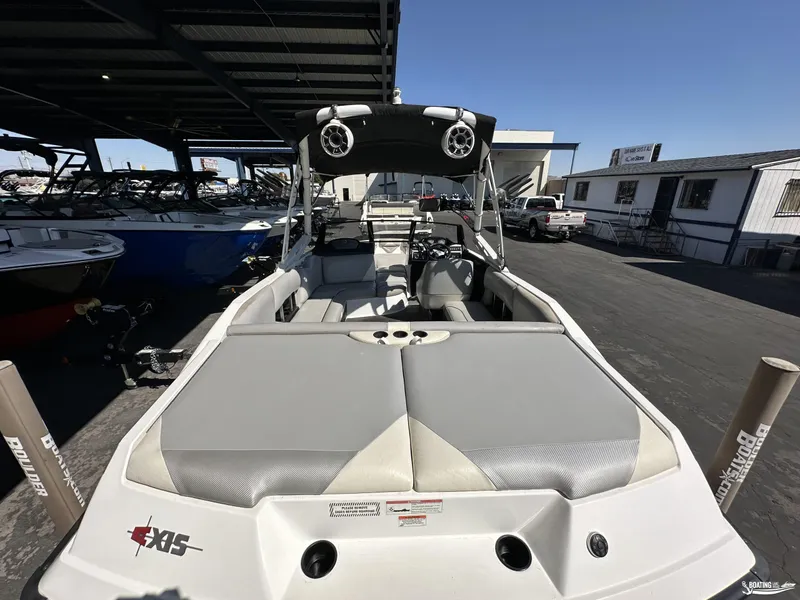 Slide: The Image of 2012 Axis A22 boat with spacious seating, parked under a canopy. - 3