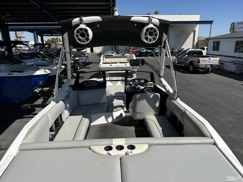 Slide: The Image of 2012 Axis A22 boat interior with seating and speakers, parked in a marina. - 4