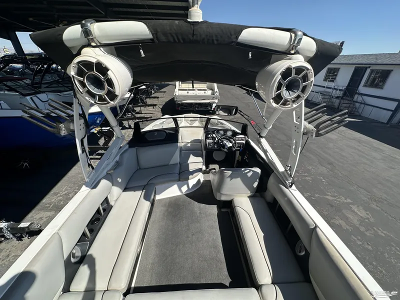 Slide: The Image of 2012 Axis A22 boat interior with seating, speakers, and control panel under a canopy. - 5