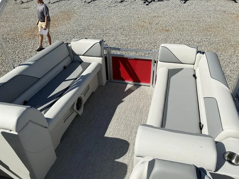 Slide: The Image of 2025 Avalon Venture 23 FT Quad Lounger interior with gray seating and red gate. - 9