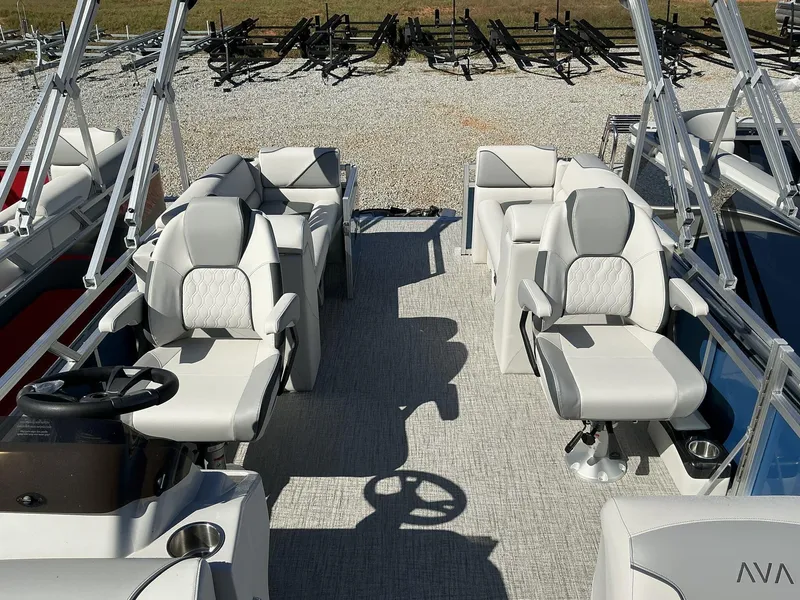 Slide: The Image of 2025 Avalon Venture 21 FT Quad Lounger boat interior with plush seating and steering wheel. - 4