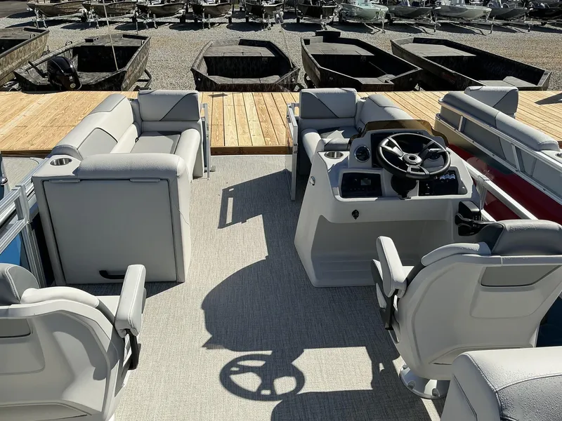 Slide: The Image of 2025 Avalon Venture 21 FT Quad Lounger boat interior with plush seating and steering console. - 7