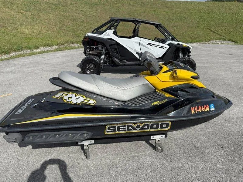 Slide: The Image of 2007 Sea-Doo RXP 215 jet ski parked beside a white off-road vehicle. - 16