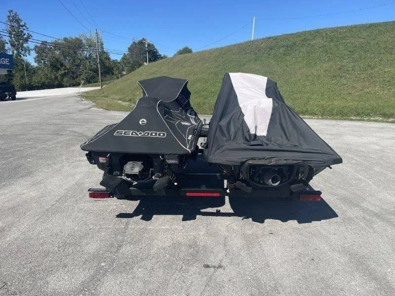 Slide: The Image of 2007 Sea-Doo RXP 215 jet skis covered on a trailer in a parking lot. - 29