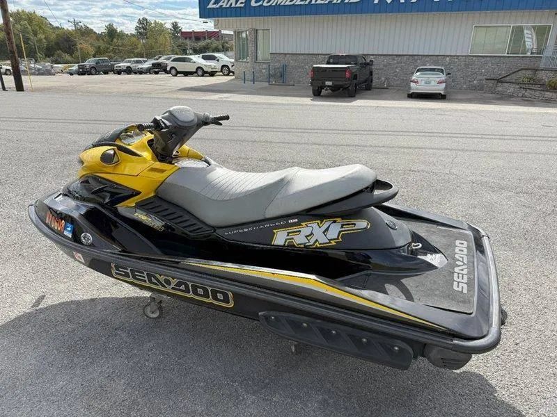 Slide: The Image of 2007 Sea-Doo RXP 215 jet ski, black and yellow, parked outdoors. - 3